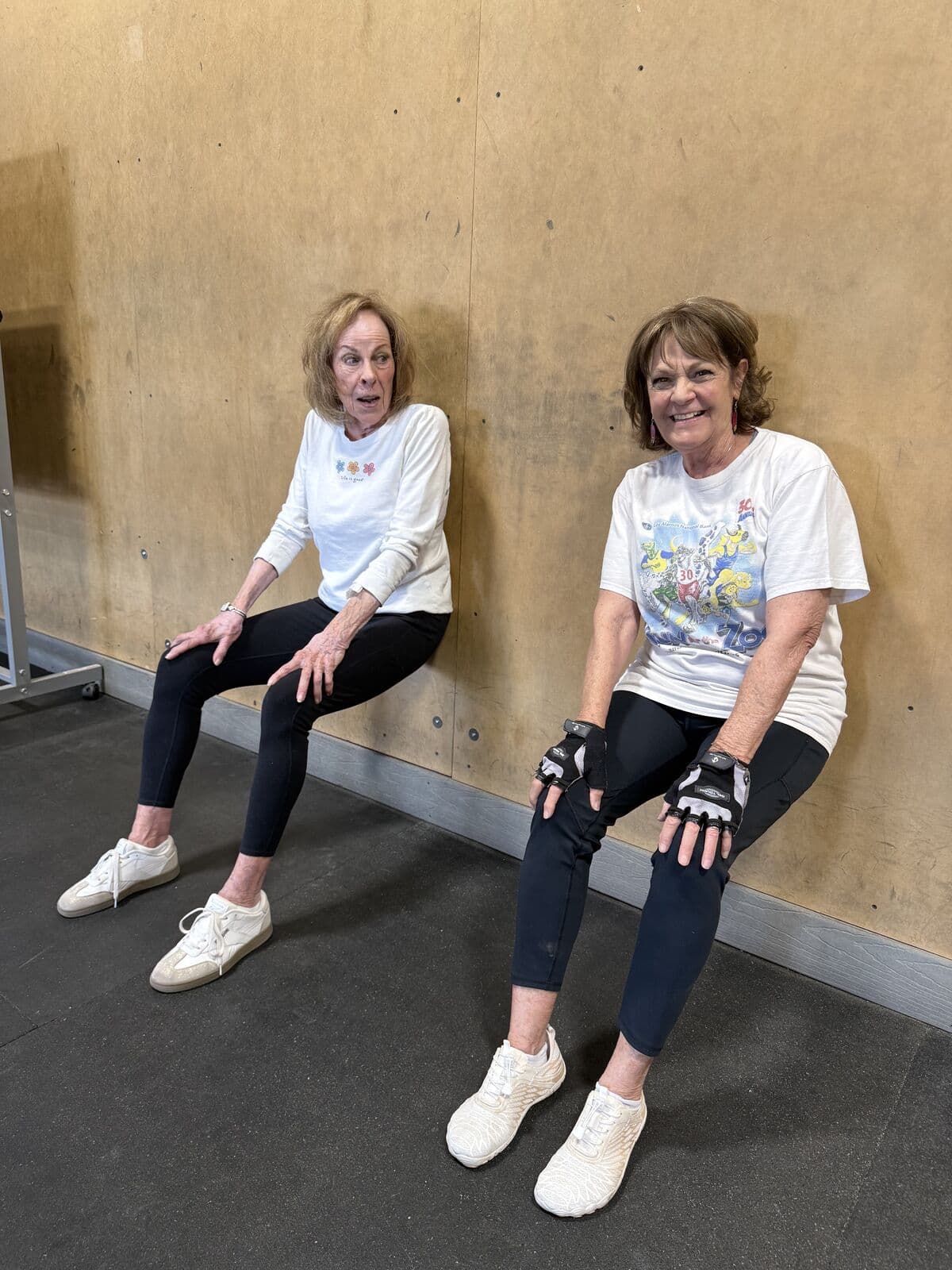 Two members holding a wall sit side by side