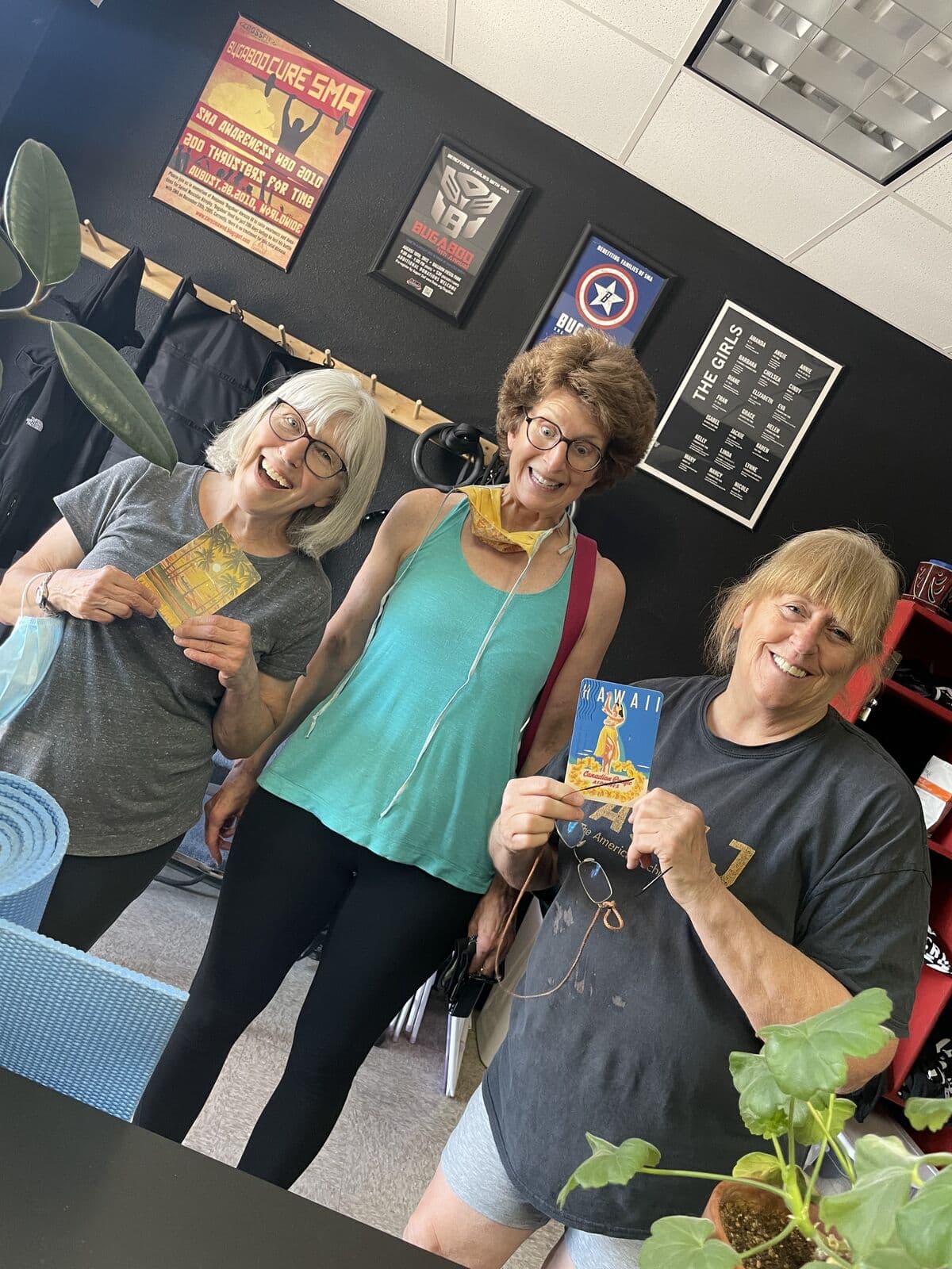 Three members holding cards in the gym lounge